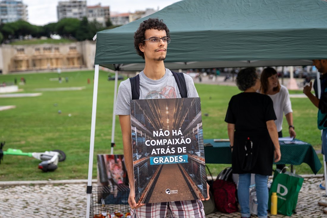 Voluntário da Frente Animal numa acção de rua com um cartaz da campanha